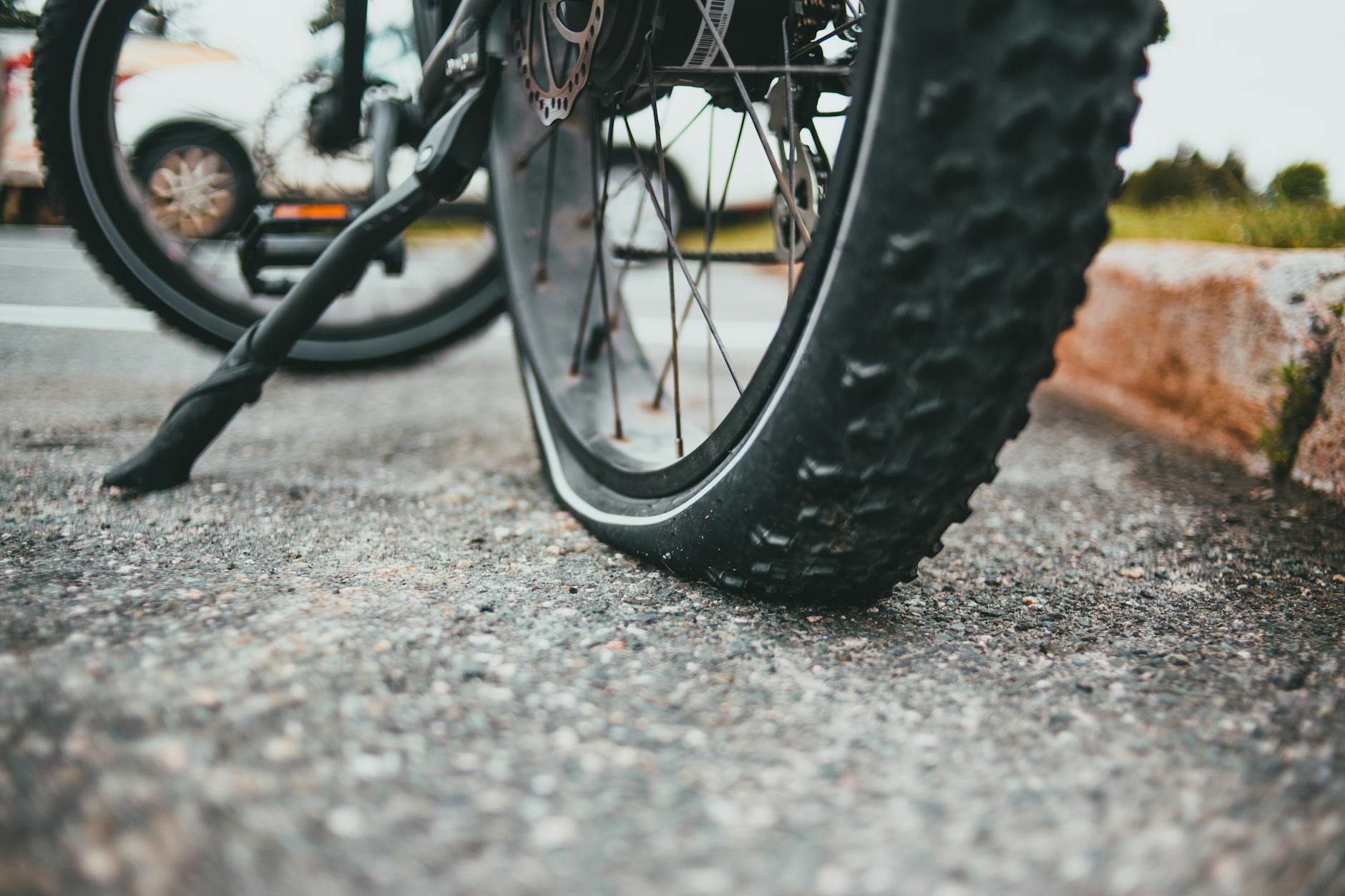 Zbliżenie przebitej opony roweru gravelowego leżącej na asfalcie