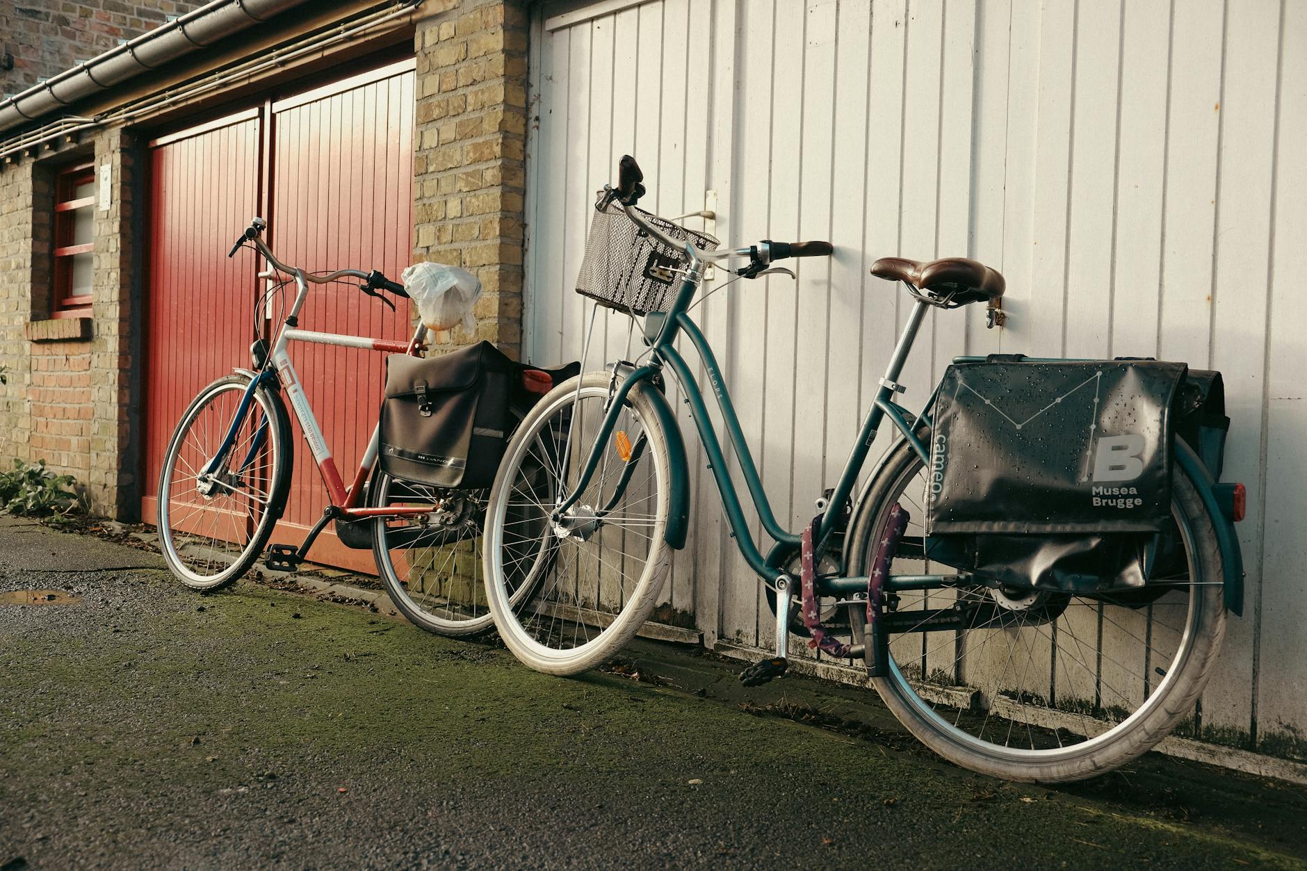 Dwa retro rowery miejskie bez błotników pod ścianą garażu