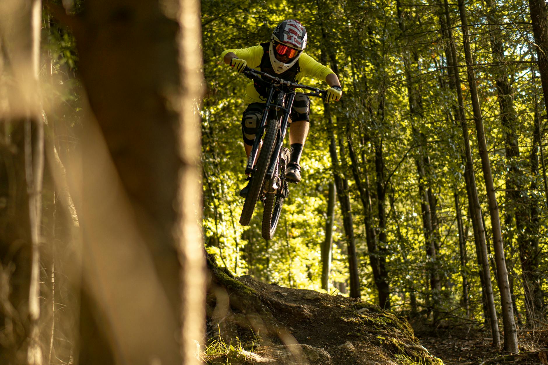 Kolarz MTB enduro w skoku na leśnym zjeździe w Niemczech