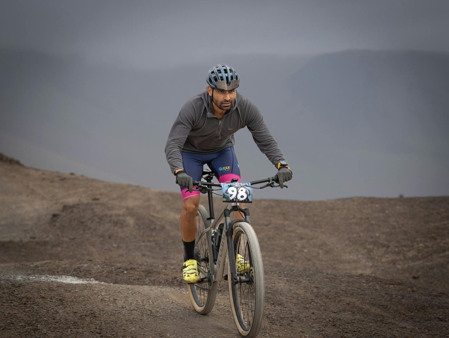 Kolarz MTB w kasku jedzie po kamienistym, górskim szlaku