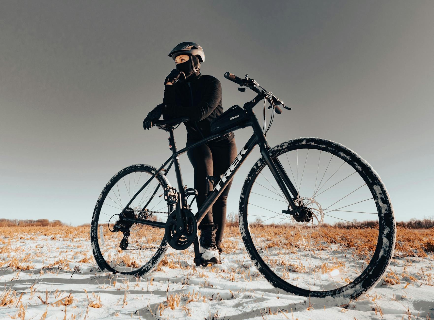 Rowerzysta z górskim rowerem na ośnieżonym polu zimą