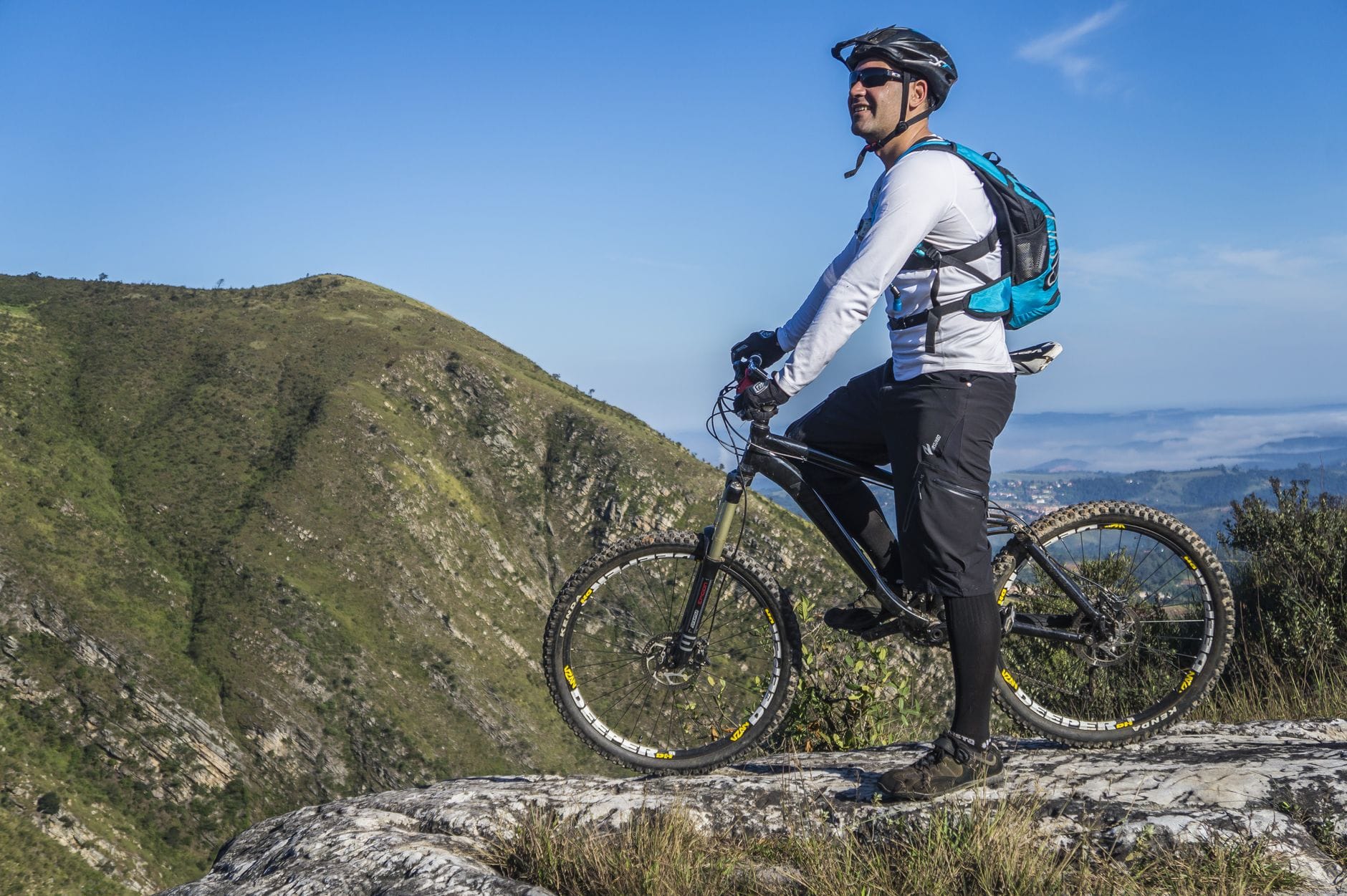 Kolarz górski na MTB z plecakiem patrzy na skalisty krajobraz