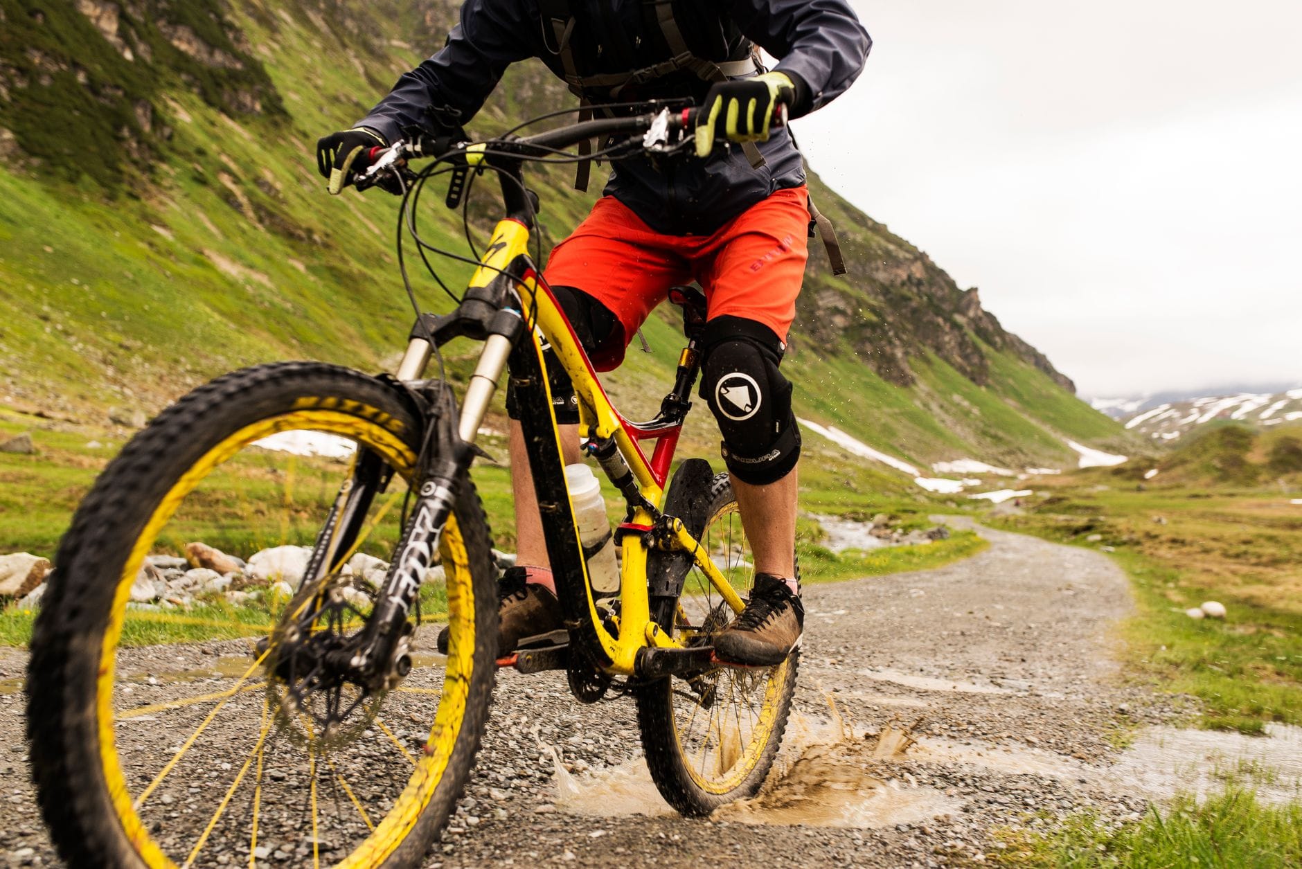 MTB hardtail dla początkujących: czy warto dopłacić do lepszego amortyzatora? Rowerzysta MTB na błotnistym szlaku w górach podczas zjazdu