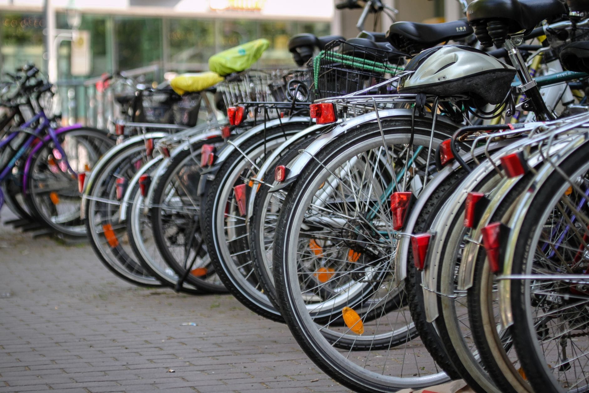 Kilka miejskich rowerów z kaskami zaparkowanych na kamiennej nawierzchni