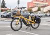 Bagażniki i uchwyty do e-bike’a na hak ranking: nośność dla ciężkich rowerów Żółty cargo e-bike z zakupami przed supermarketem we Francji